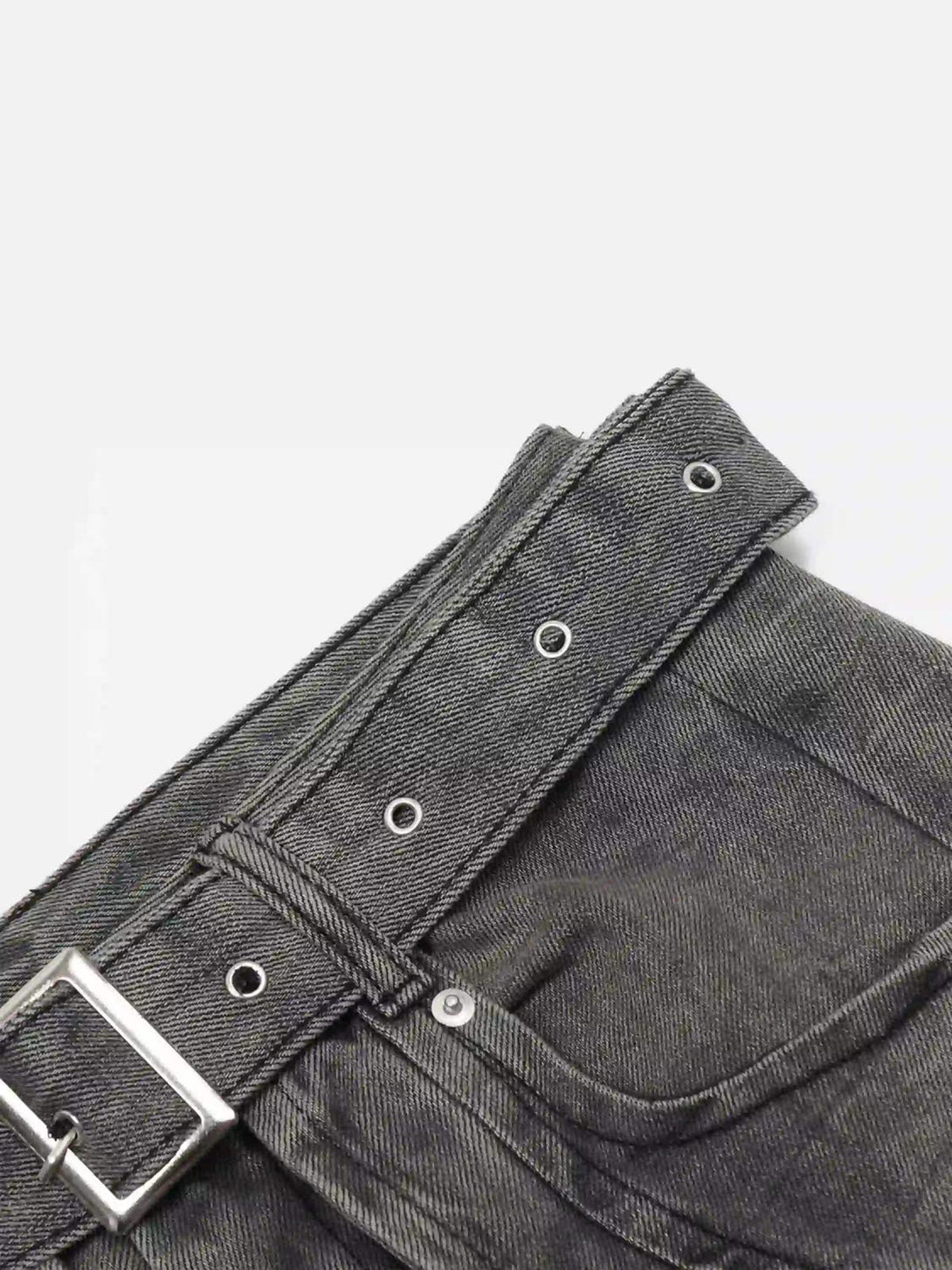 Close-up of TALISHKO's distressed punk jeans, highlighting the textured fabric and metal belt.