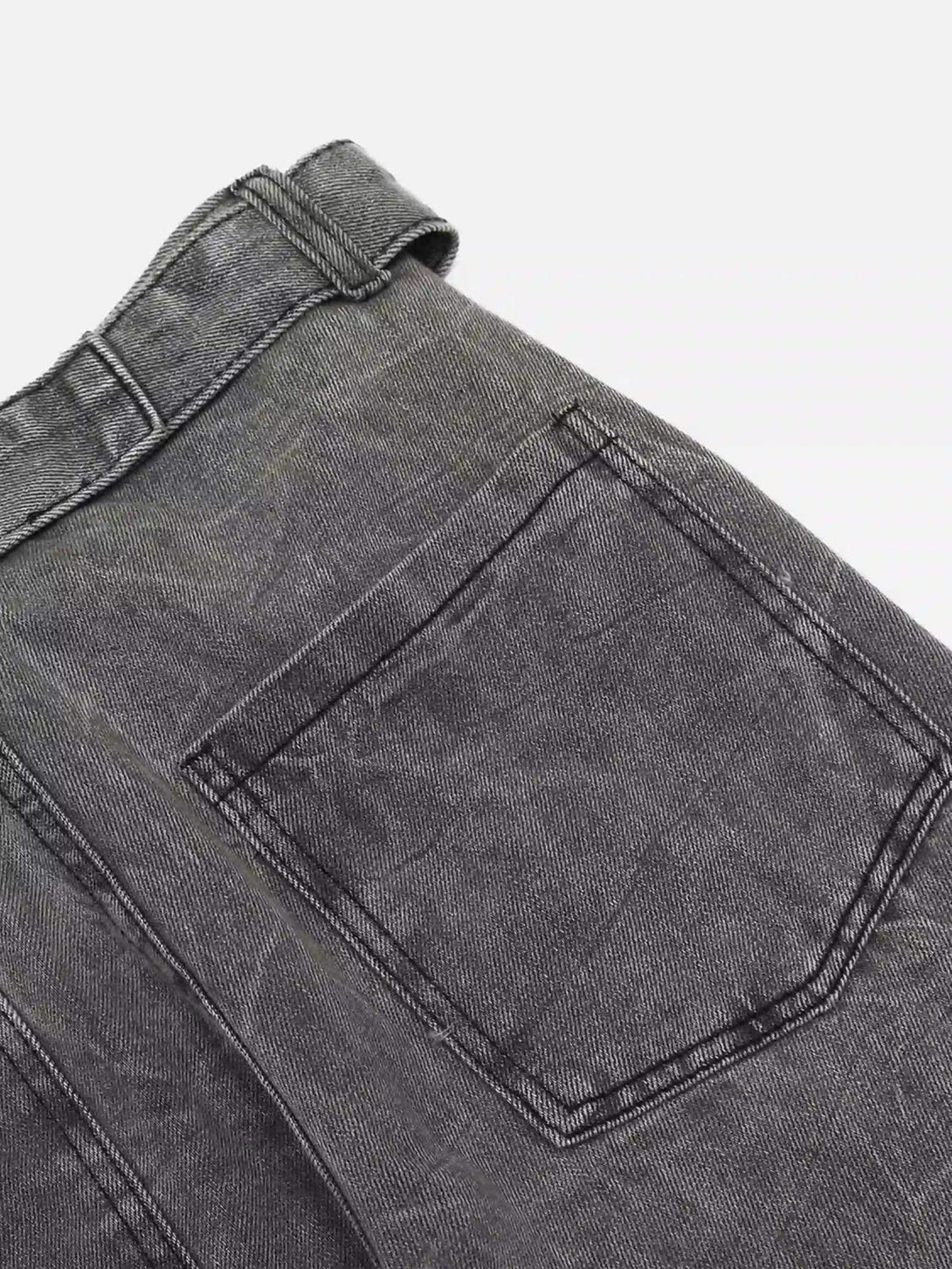 Detailed fabric and stitching on TALISHKO's distressed punk jeans, highlighting back pocket design.