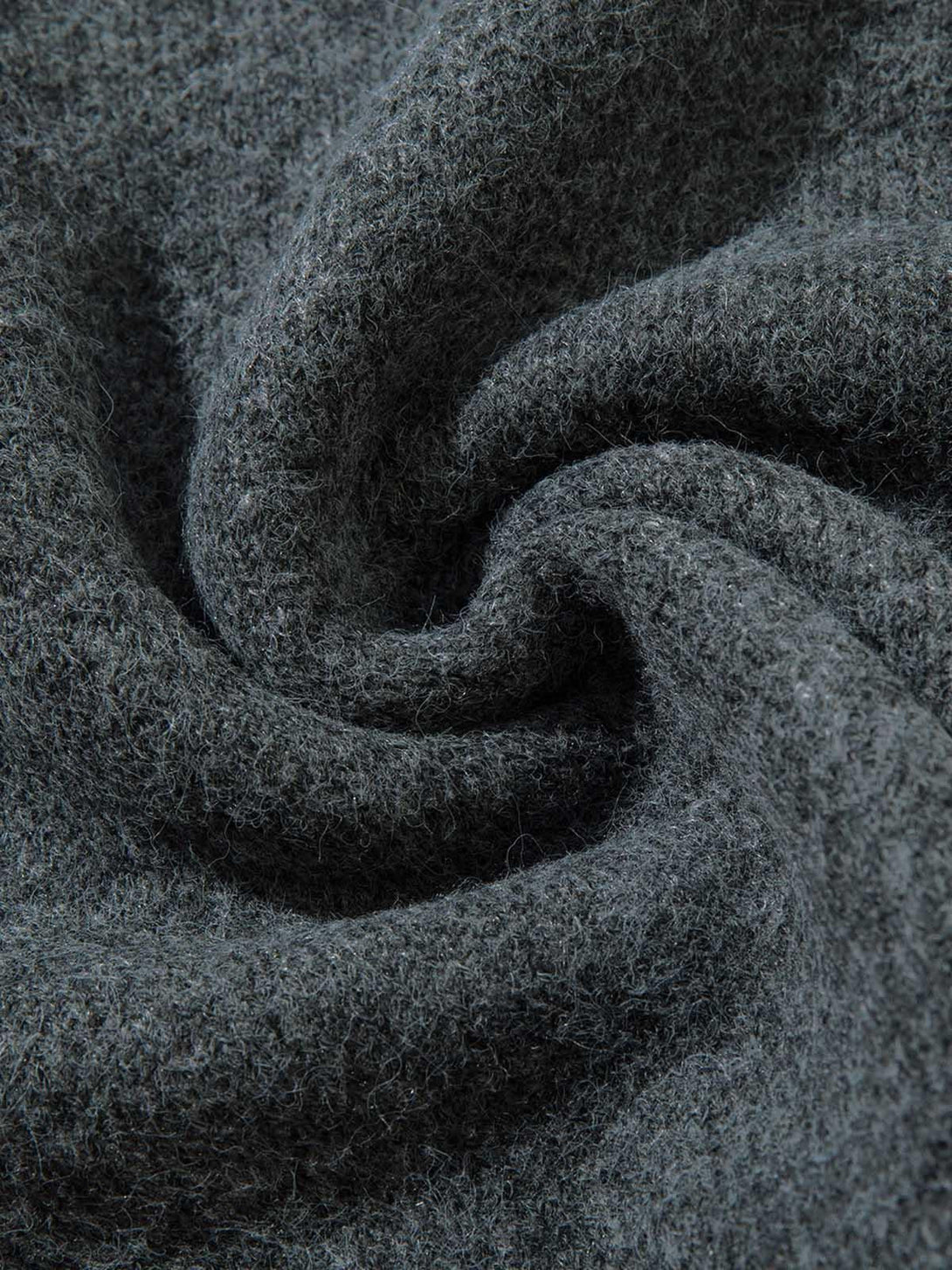 A close-up of the soft, textured fabric on a TALISHKO distressed quarter zip sweater.