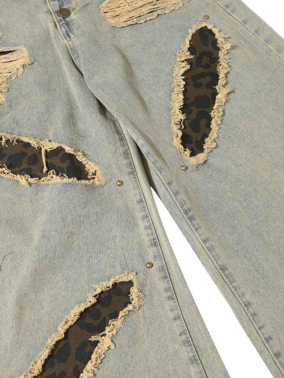 Detailed view of TALISHKO jeans, highlighting distressed patches and textured fabric accents.