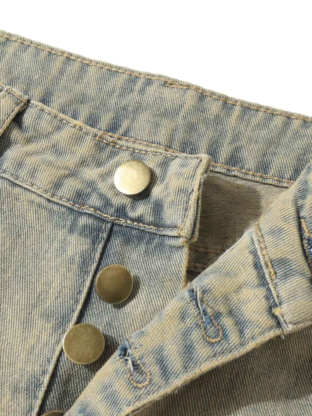 Detailed fabric and button view of TALISHKO distressed jeans, showcasing raw edge accents.