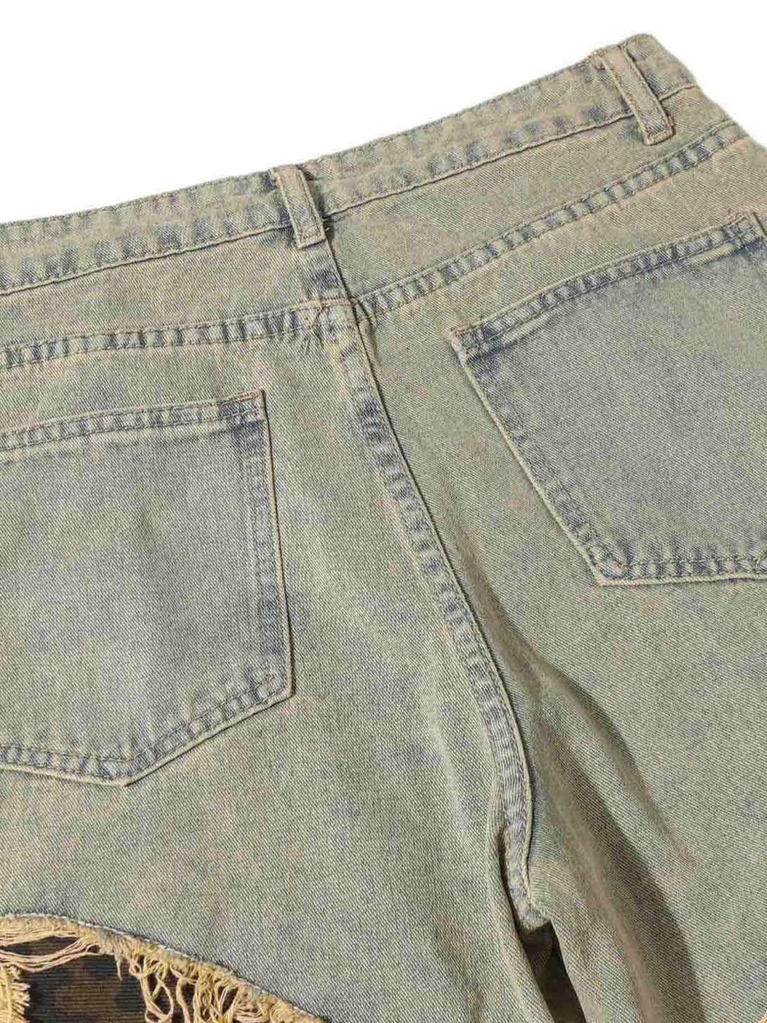 Back view of TALISHKO jeans, featuring distressed patches and raw edge details.