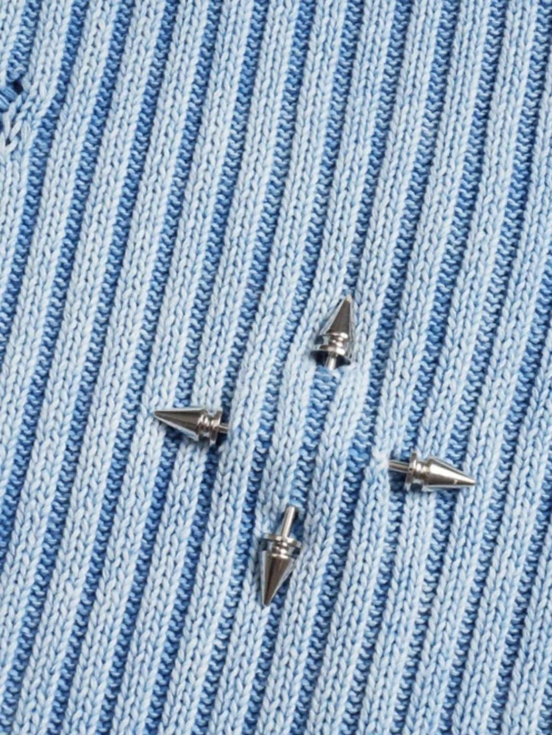 Intricate look at rivet details on a blue sweater by TALISHKO, showcasing texture and style.