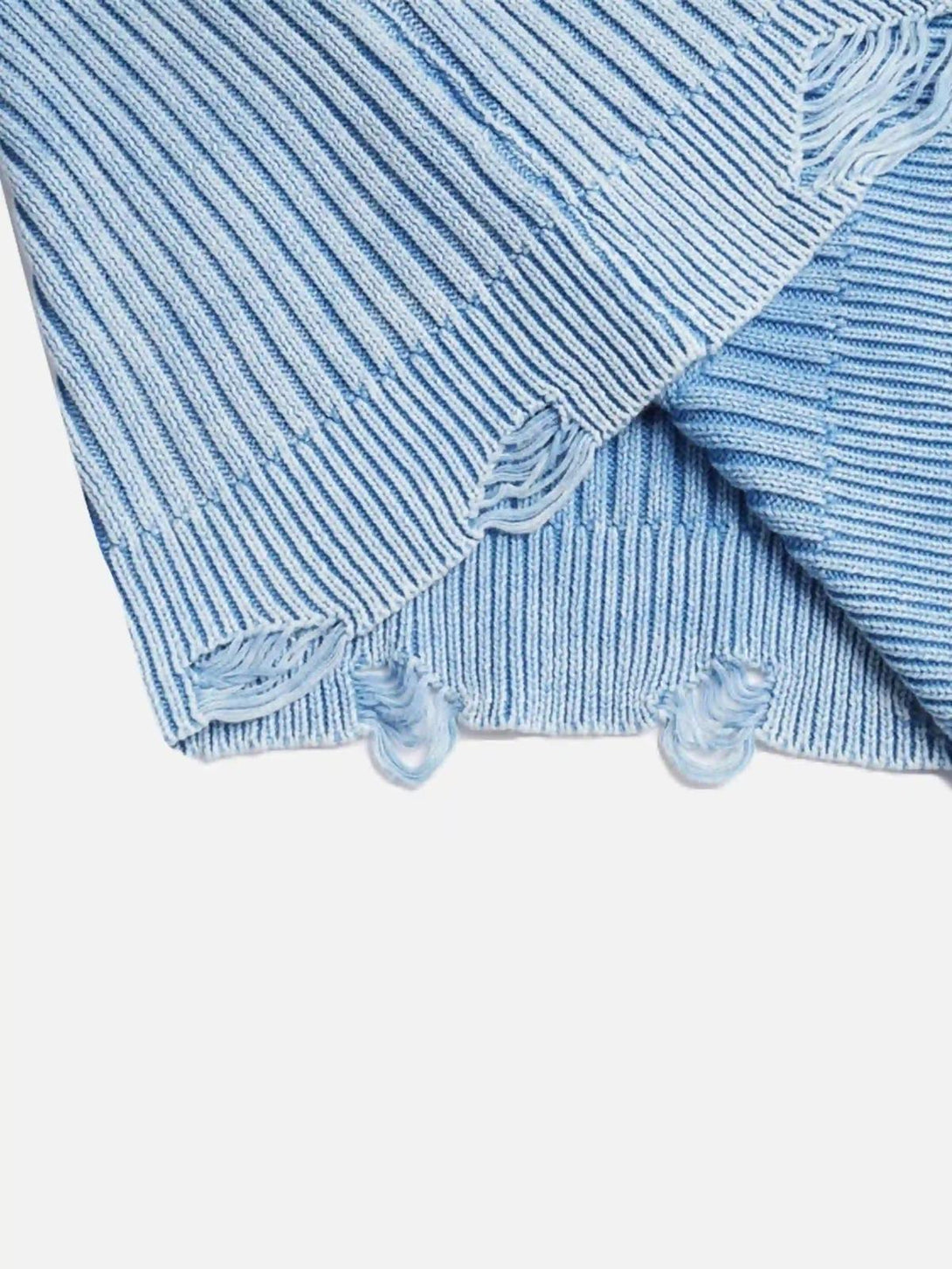 A tight crop highlighting the distressed edges and knit texture of a blue sweater by TALISHKO.