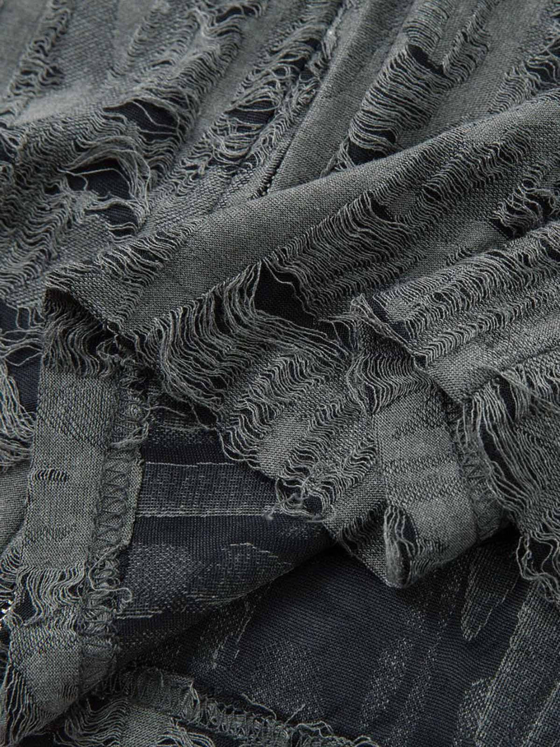 Intricate look at the distressed texture of a TALISHKO short sleeve shirt, showcasing unique details.