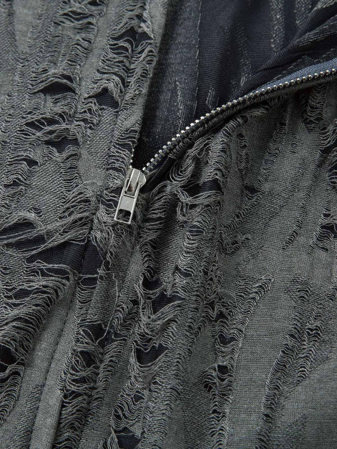 Detailed fabric and stitching on a TALISHKO distressed short sleeve shirt with a ripped design.