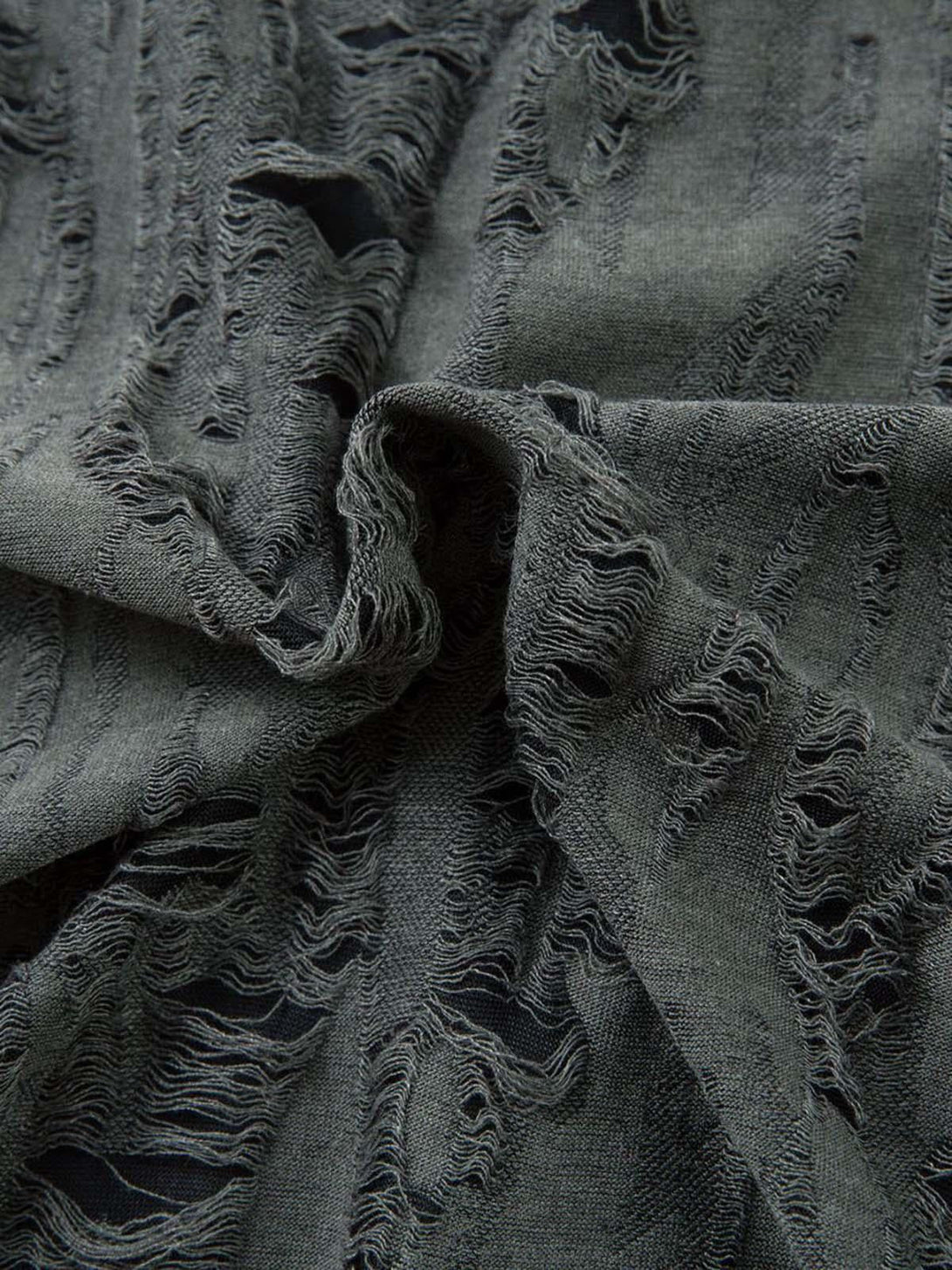 Intricate look at the distressed fabric of a TALISHKO short sleeve shirt, showcasing unique design.