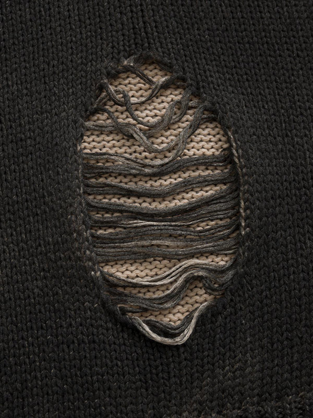 A tight crop highlighting the distressed knit detail on a pullover sweater by TALISHKO.