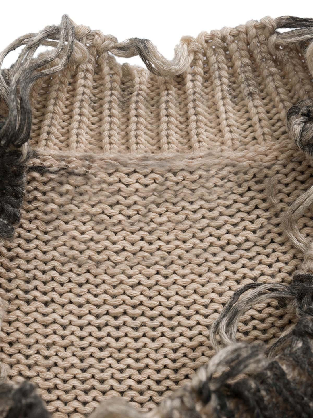 A detailed view of the knit texture and distressed edges on a pullover sweater by TALISHKO.