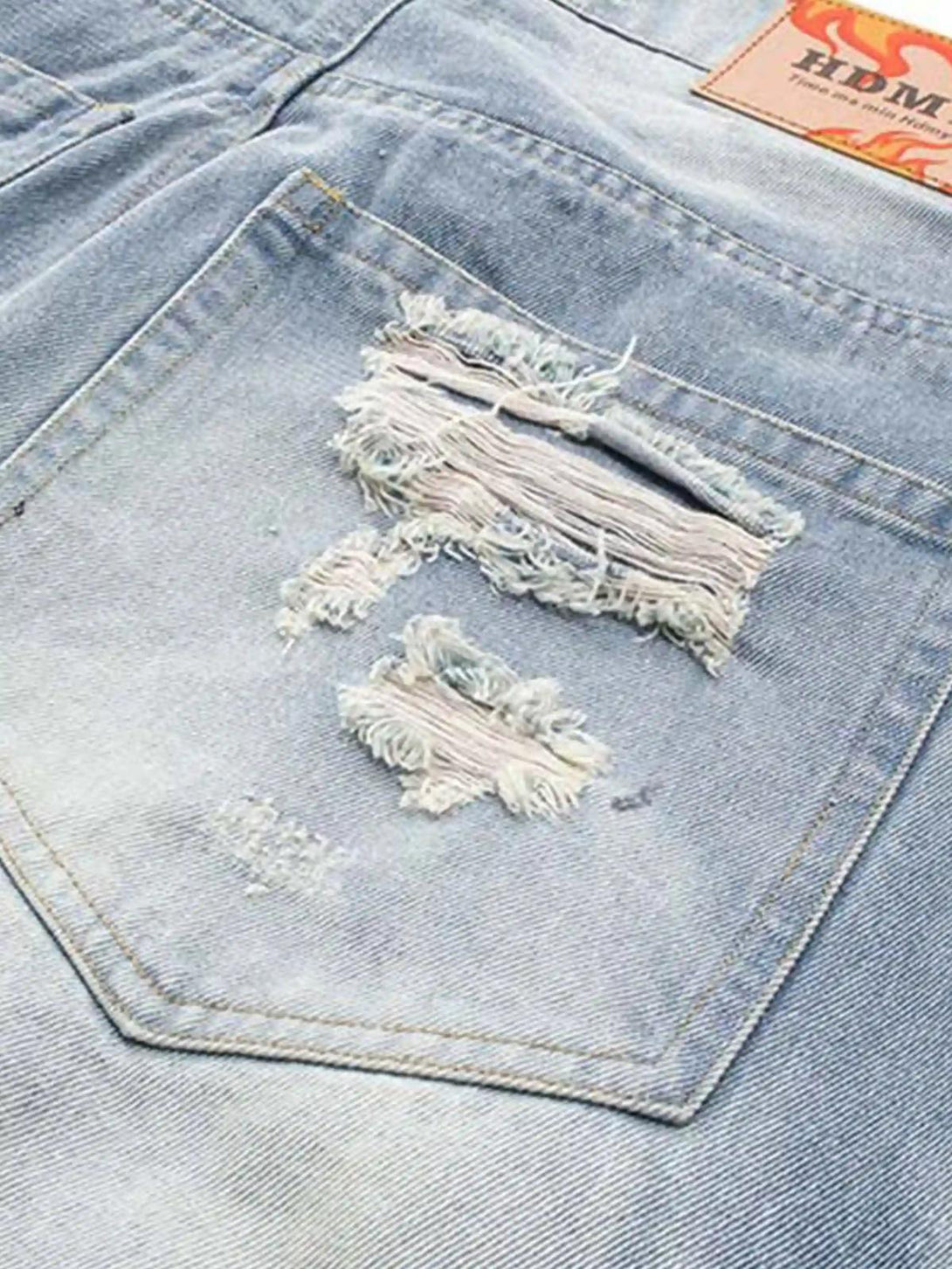 Detailed look at the distressed back pocket of TALISHKO jeans, highlighting rugged texture.