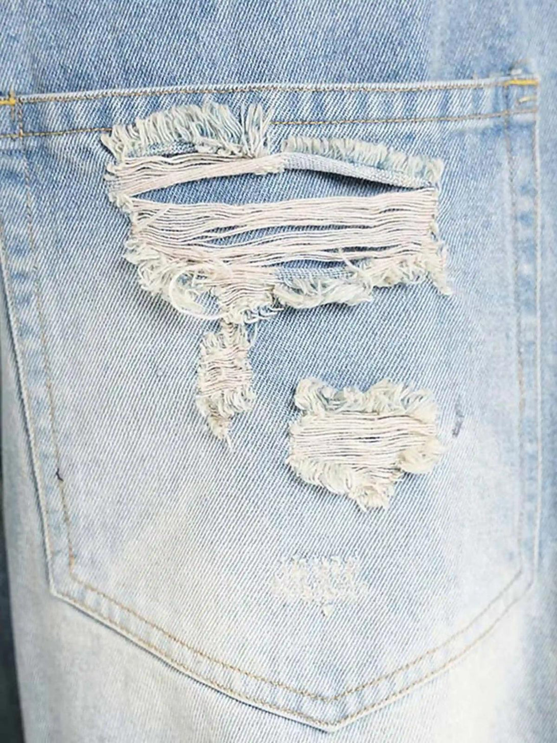 Distressed fabric detail on TALISHKO jeans, showcasing rugged texture and unique style.