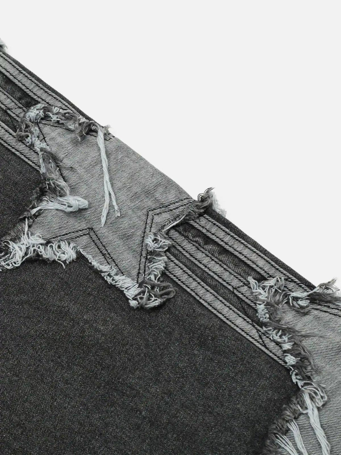 Intricate detailing of TALISHKO distressed jeans, showcasing frayed star patch design.