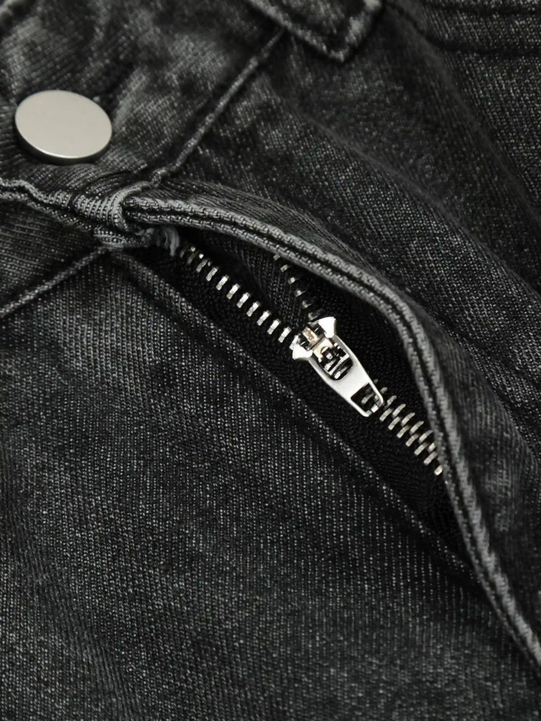 A detailed view of TALISHKO distressed jeans, highlighting the zipper and rugged texture.