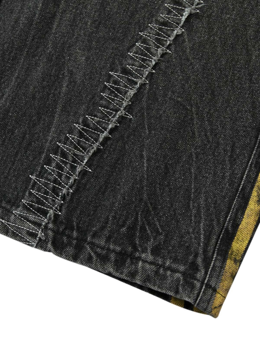 Zoomed-in view of TALISHKO jeans showcasing intricate stitching and patchwork detailing.