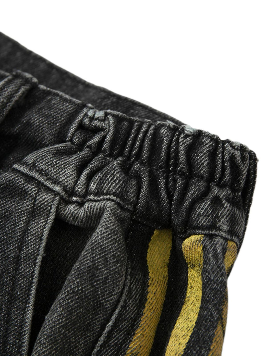 Elastic waistband detail of TALISHKO jeans with yellow side stripes and textured denim.