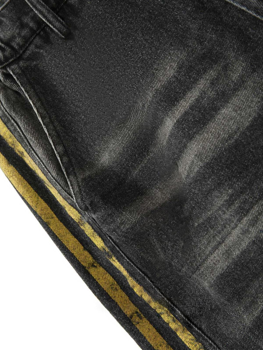 Intricate look at TALISHKO jeans, highlighting yellow striped side and distressed fabric.
