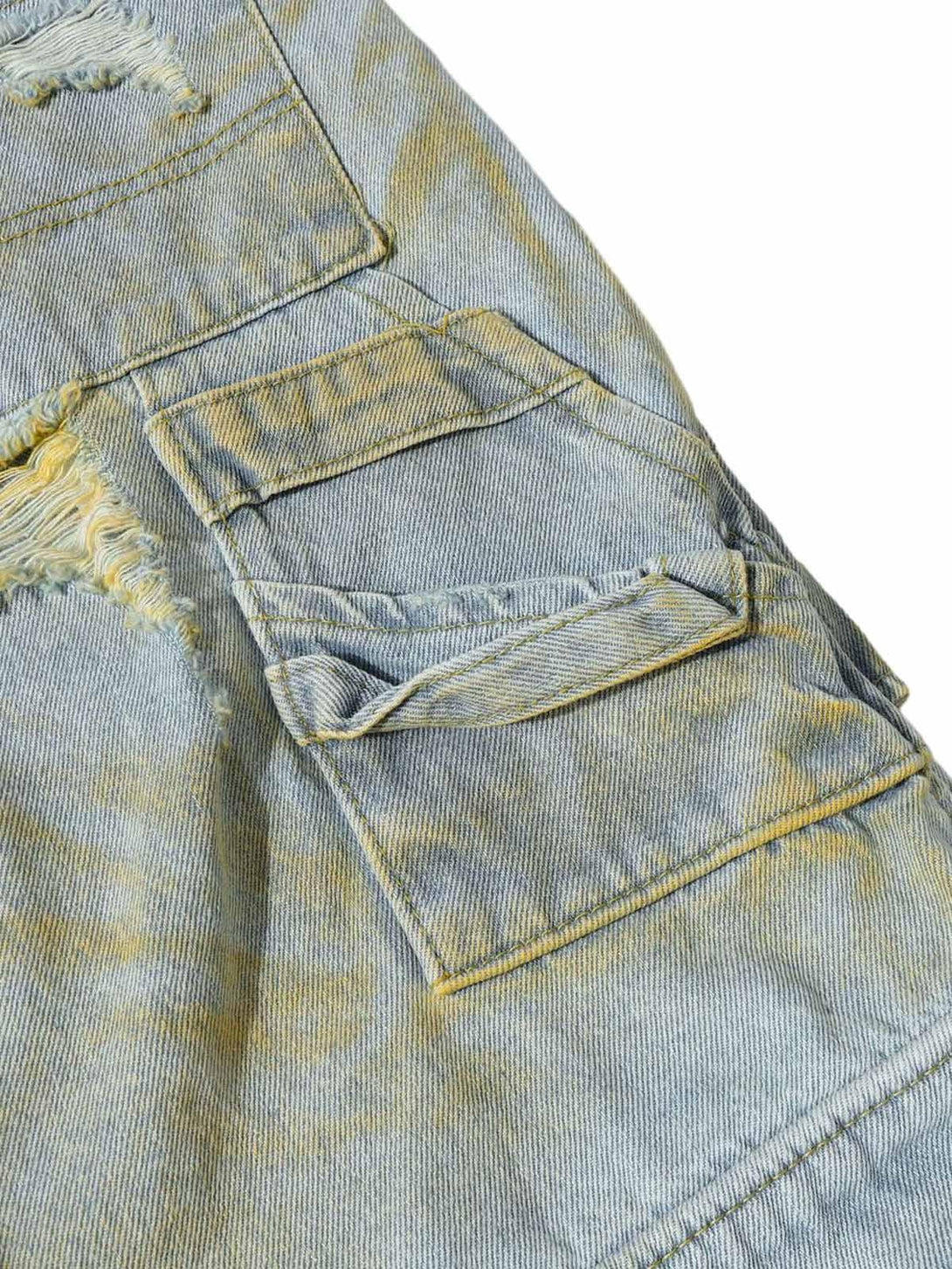 Intricate look at TALISHKO distressed tie-dye denim shorts pocket detail and frayed edges.