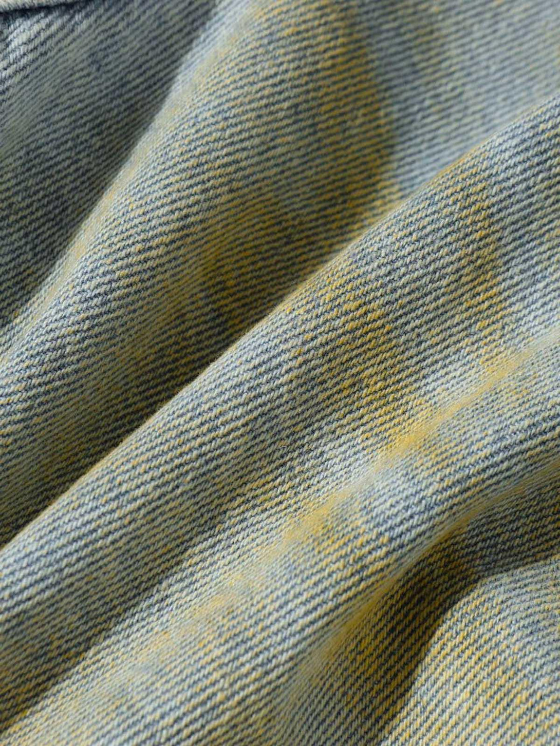 Texture and pattern showcased in TALISHKO's distressed tie-dye denim, highlighting rugged style.