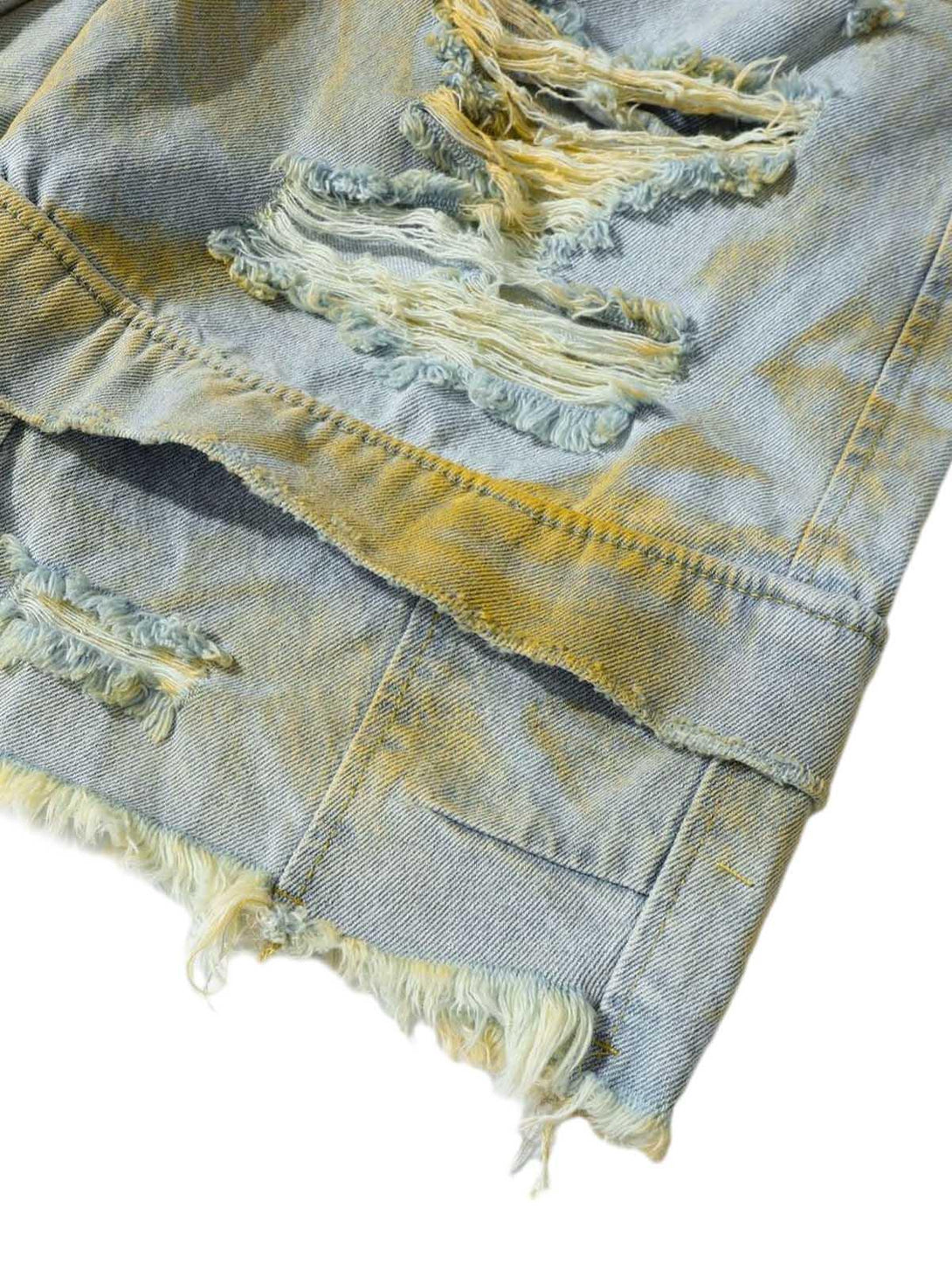 Frayed detailing on TALISHKO's distressed tie-dye denim shorts, showcasing rugged texture.