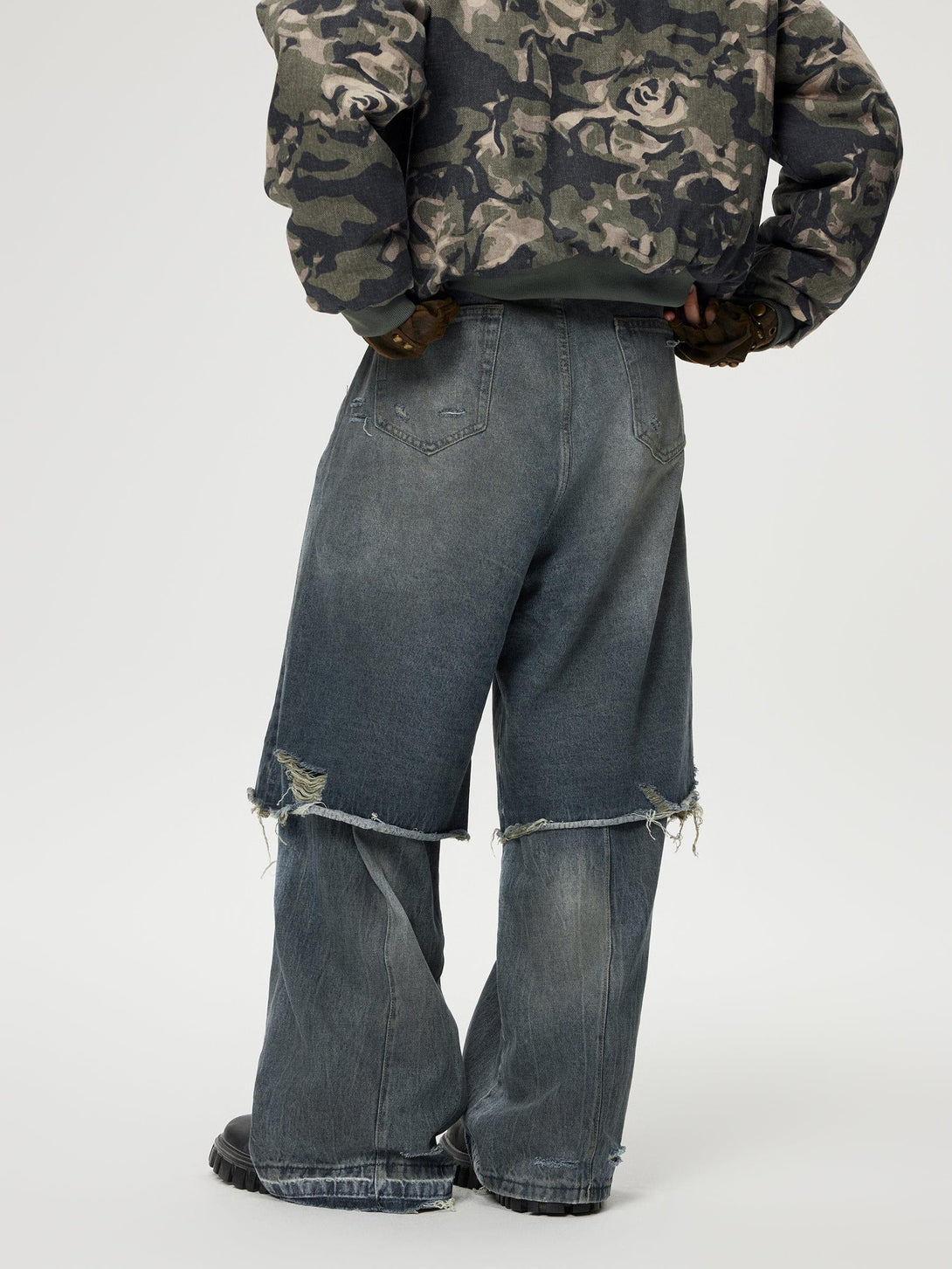 Back view of TALISHKO's distressed baggy jeans with layered design, emphasizing streetwear style.