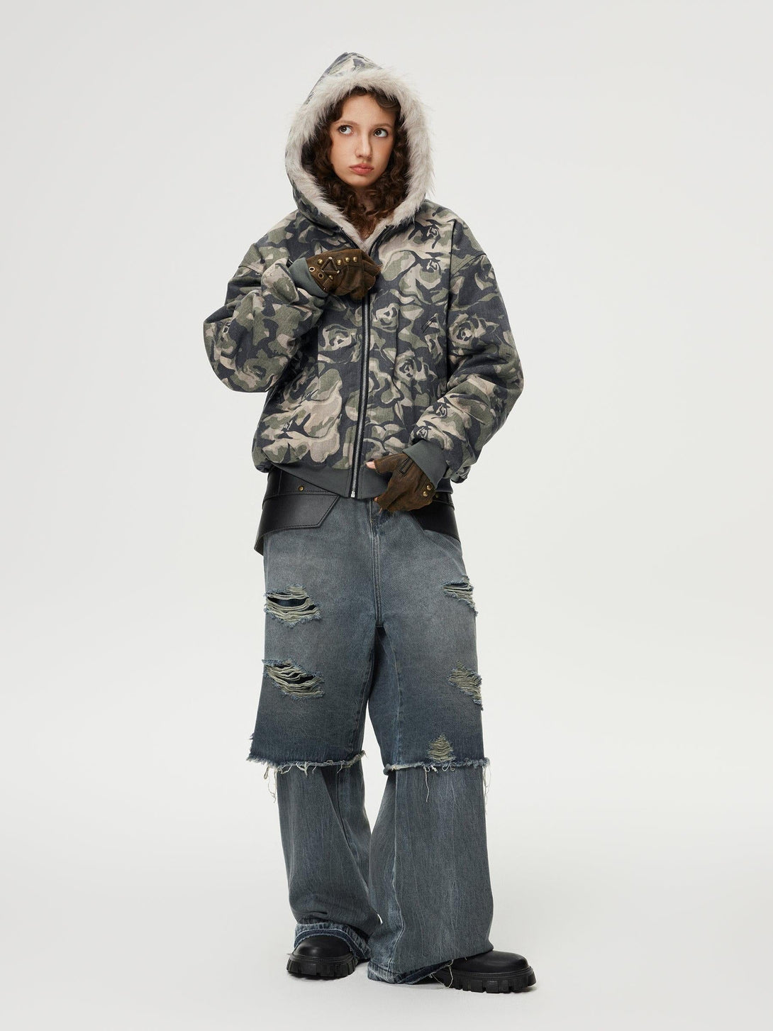 Model in TALISHKO floral camo jacket and distressed baggy jeans, highlighting urban fashion.