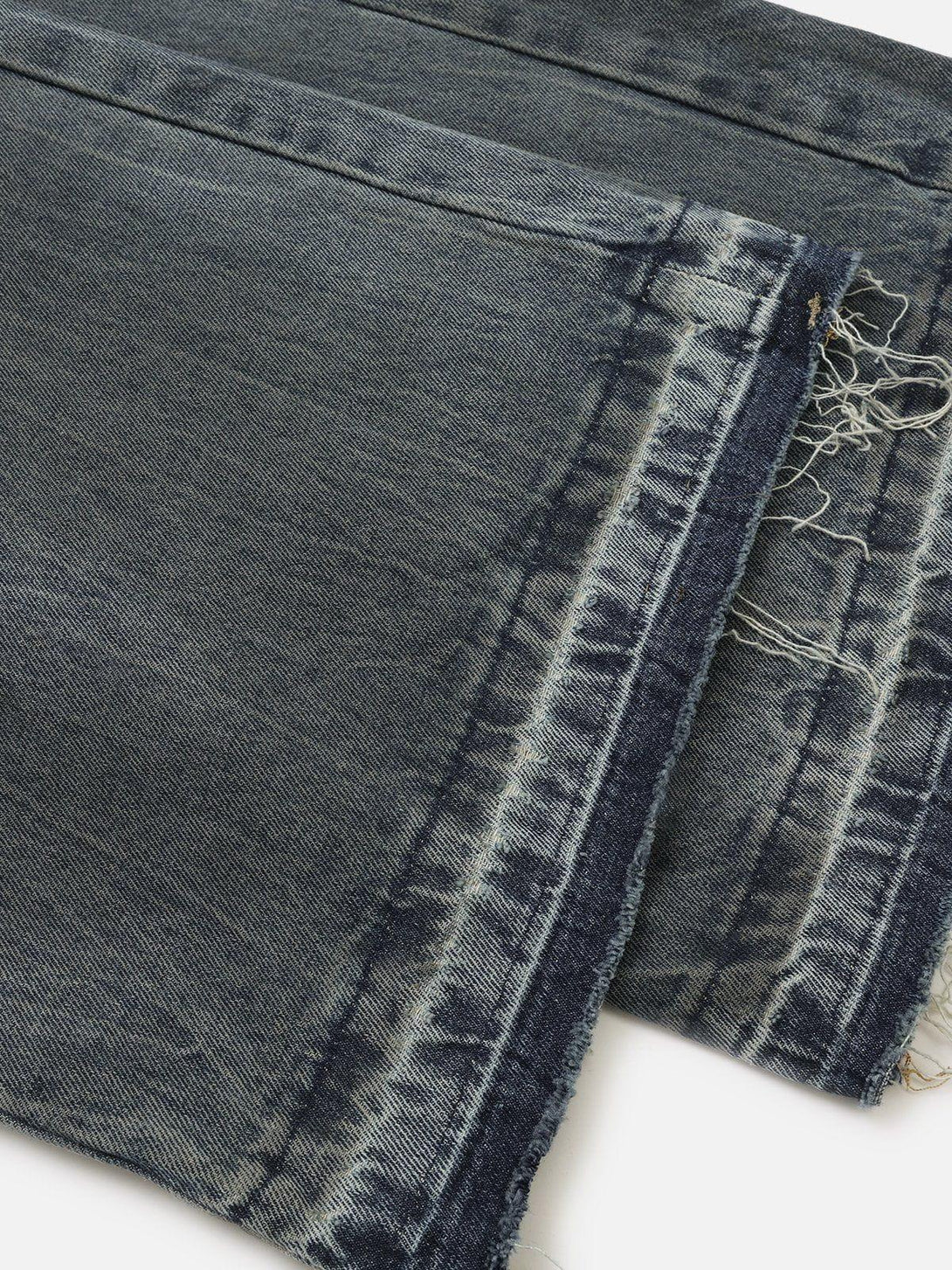 Intricate look at TALISHKO's distressed baggy jeans, emphasizing layered fabric details.