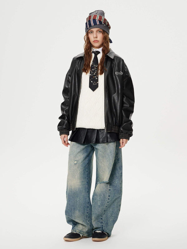 Model wearing TALISHKO distressed washed barrel jeans with a layered top and leather jacket.