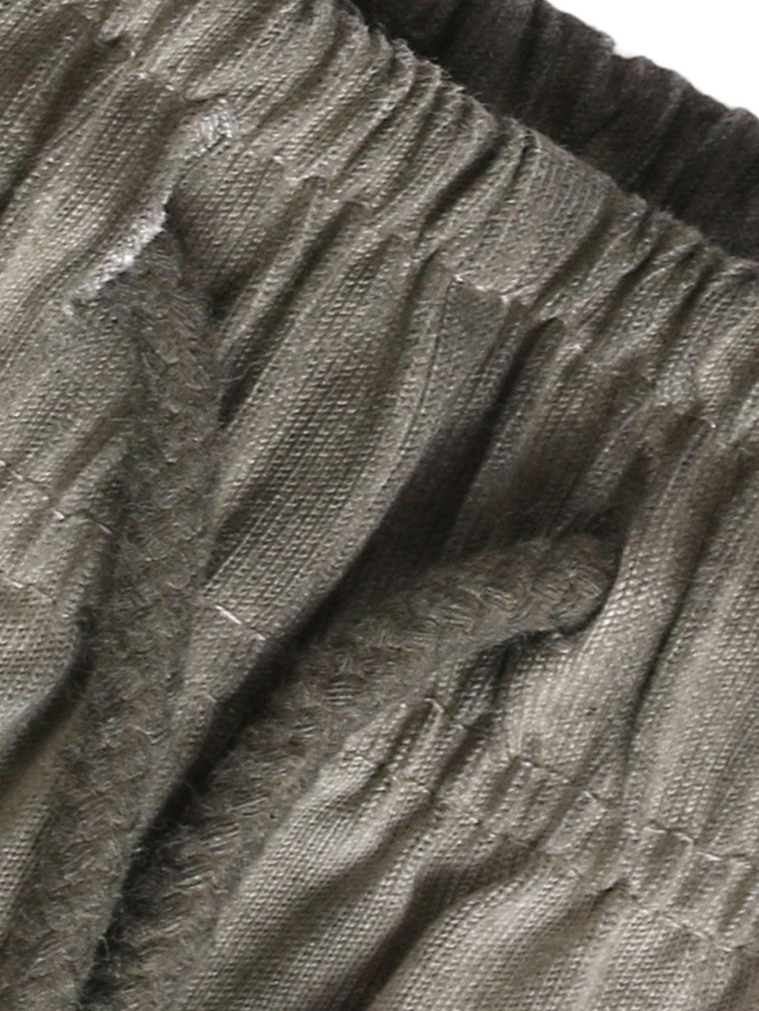 Zoomed-in texture of TALISHKO drawstring shorts, highlighting the distressed washed fabric.