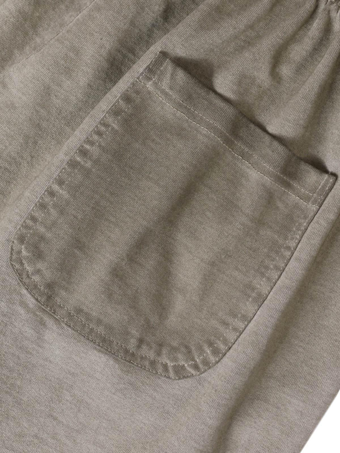 A tight crop highlighting the pocket detail on TALISHKO drawstring shorts with a washed texture.