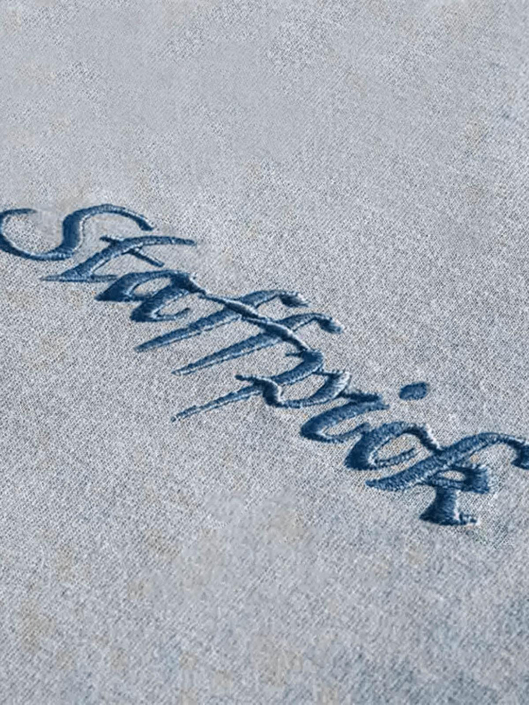 A tight crop highlighting the embroidered detail on TALISHKO's gradient vest, showcasing texture.