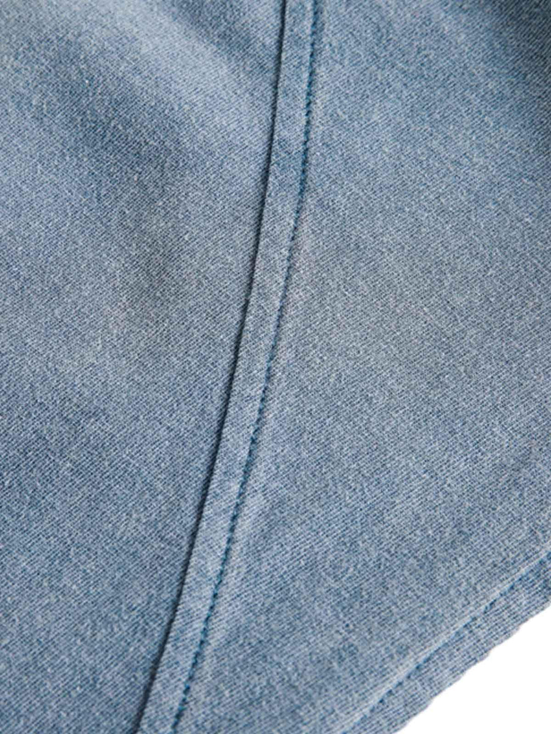 A zoomed-in texture of TALISHKO's gradient vest, highlighting the distressed fabric and stitching.