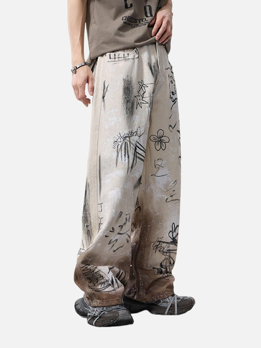 Model in TALISHKO graffiti print baggy jeans, featuring a distressed and artistic streetwear vibe.