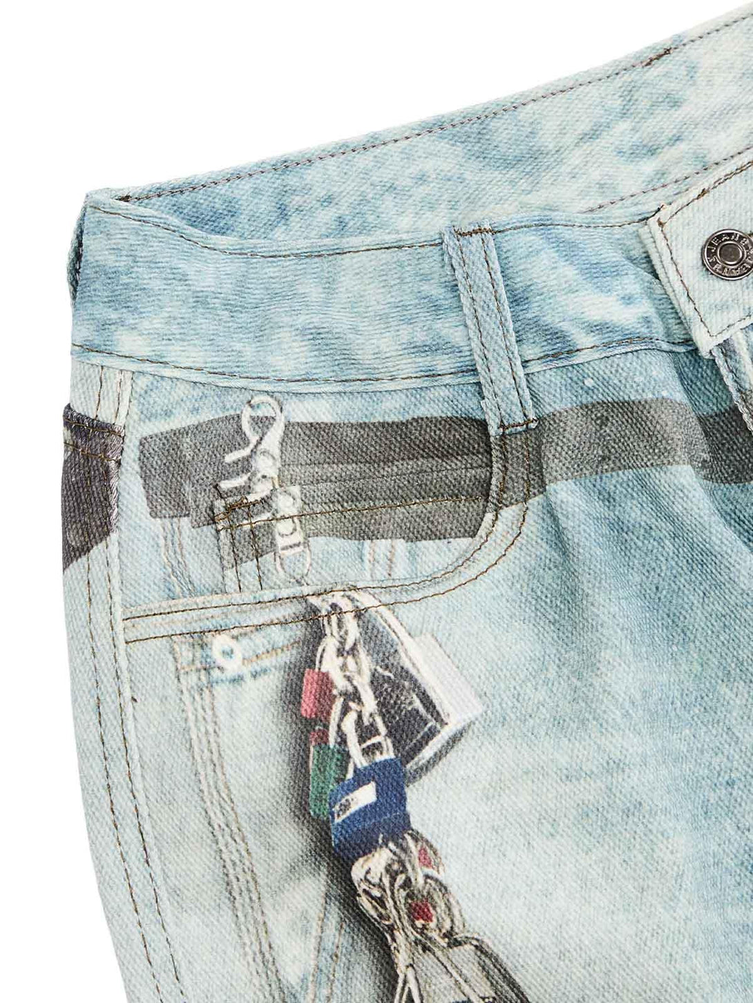 Chain print detail on TALISHKO's distressed baggy jeans, highlighting ink-splashed style.