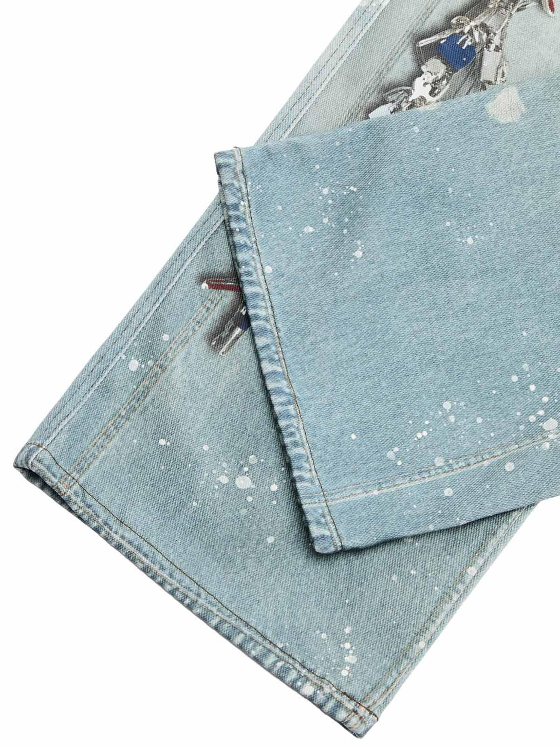 Detailed fabric and ink-splashed design on TALISHKO's baggy jeans, showcasing unique style.
