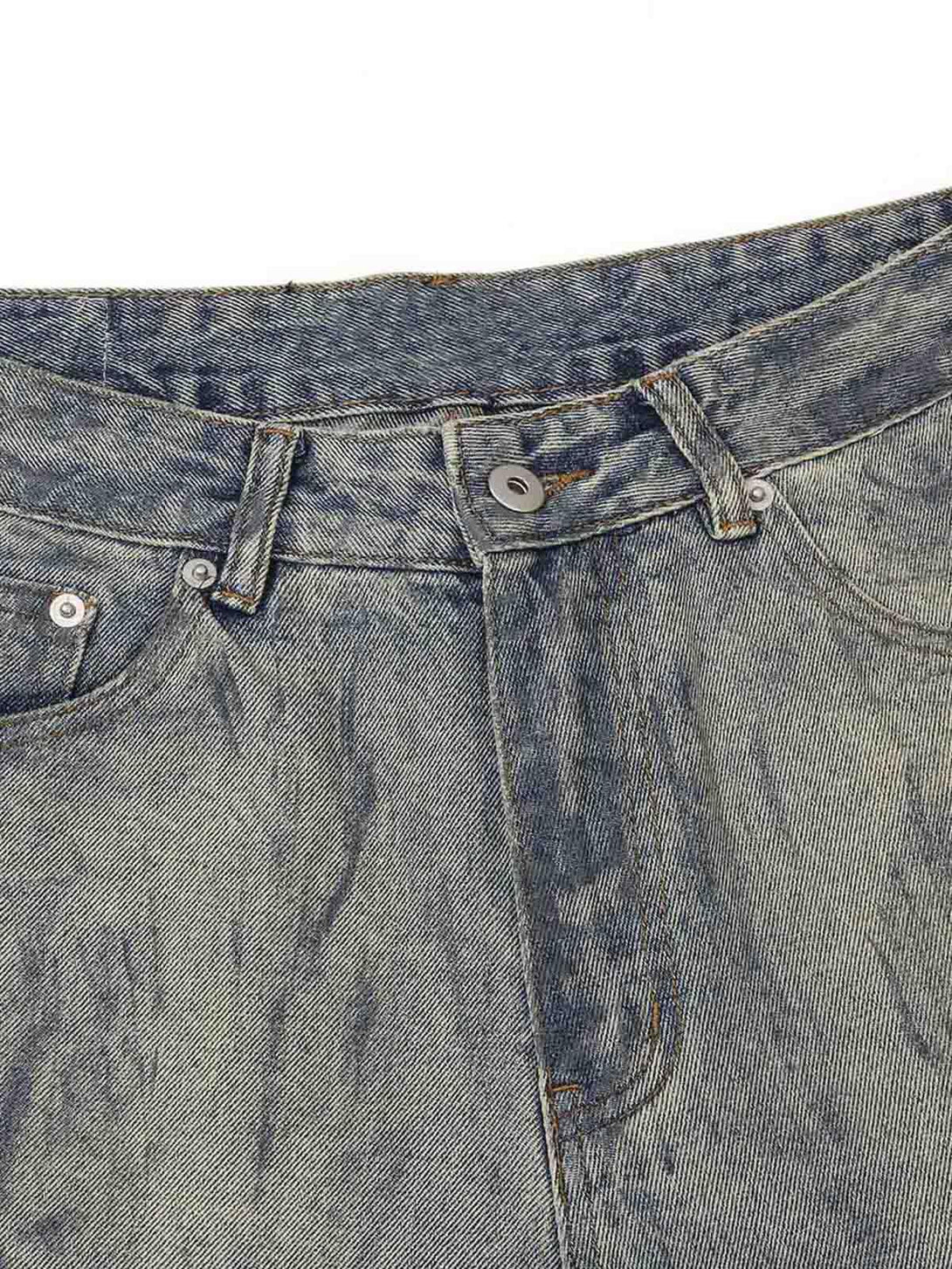Zoomed-in texture of TALISHKO distressed jeans showcasing unique washed ink-splashed detail.
