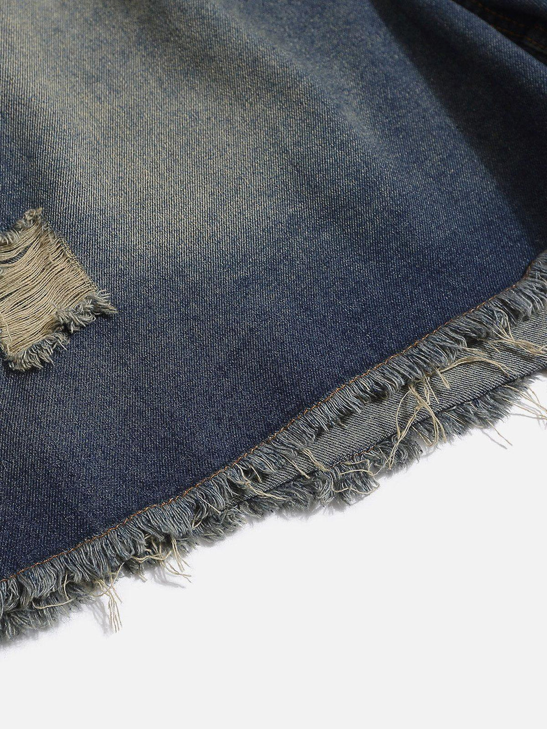 Frayed hem detail of distressed washed jorts by TALISHKO, highlighting rugged texture.