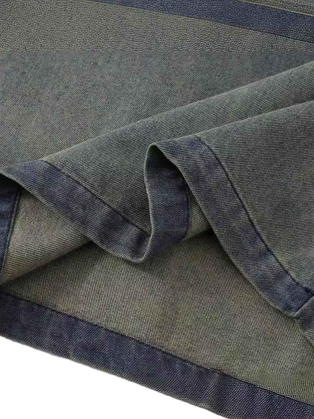 A close-up of TALISHKO's denim T-shirt, showcasing the washed texture and intricate stitching.