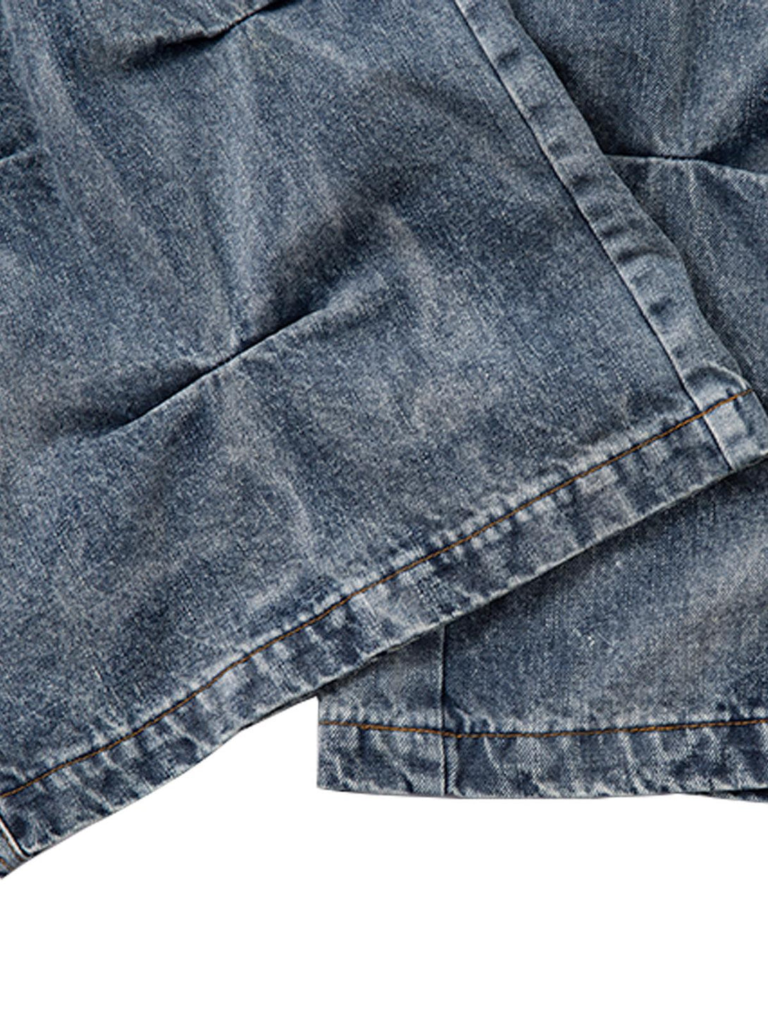 Detailed view of TALISHKO distressed washed pleated jeans, focusing on unique fabric texture.