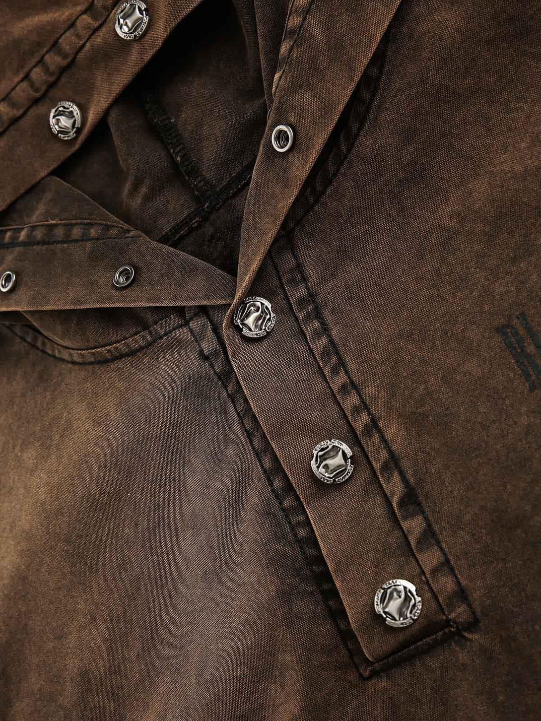 Intricate look at the TALISHKO denim sweatshirt's rivet details and distressed texture.