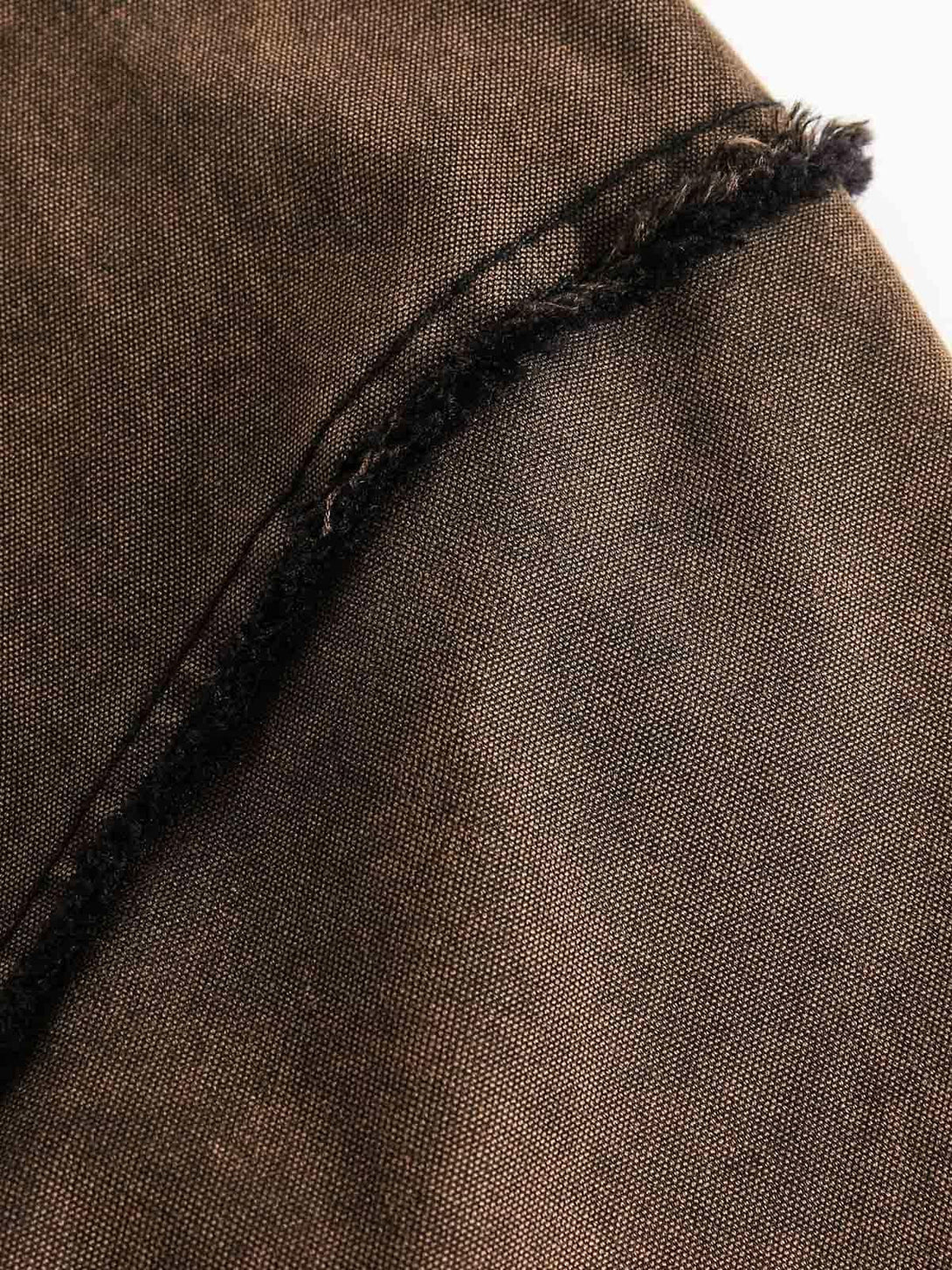 Zoomed-in view of TALISHKO's denim sweatshirt, highlighting its distressed texture and edge.