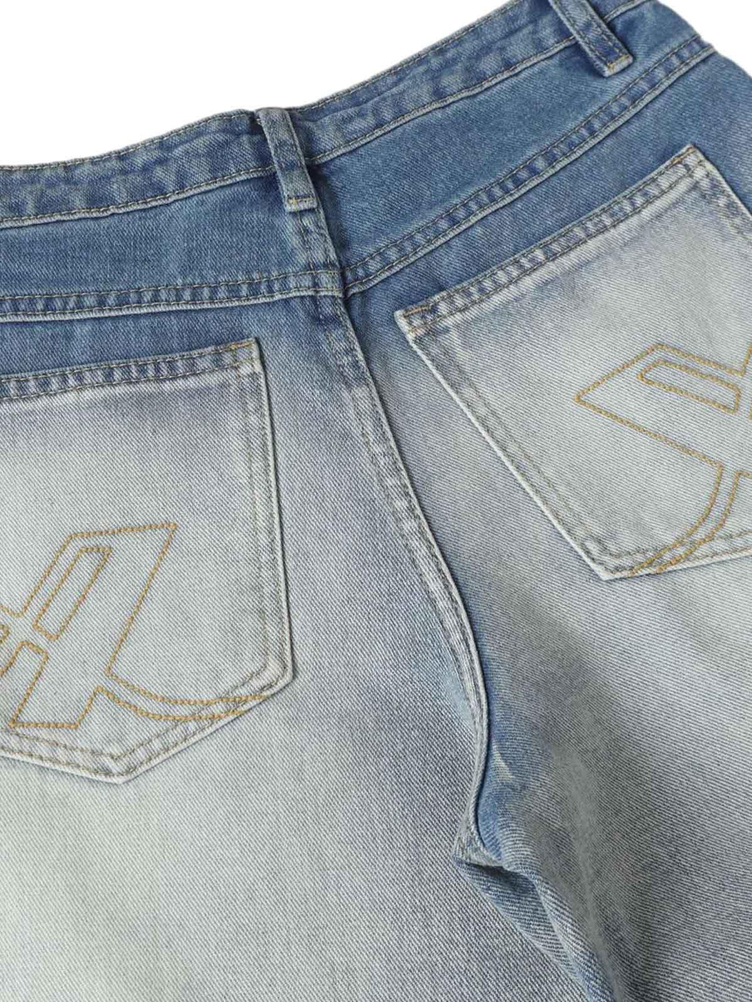 TALISHKO jeans close-up highlighting distressed whisker detail and pleated back pockets.