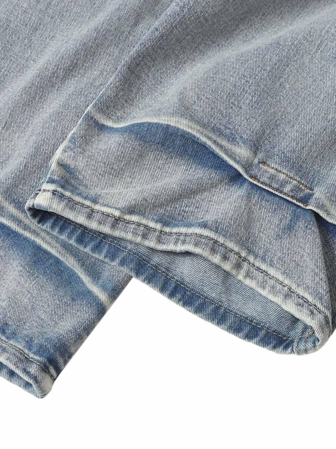 Focusing on the texture, TALISHKO jeans' distressed whisker detailing and pleated design.