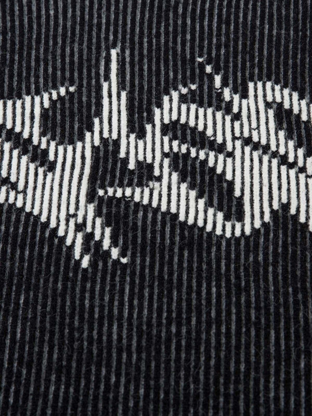 Zoomed-in texture of TALISHKO's sweater, showcasing intricate striped and graphic pattern.
