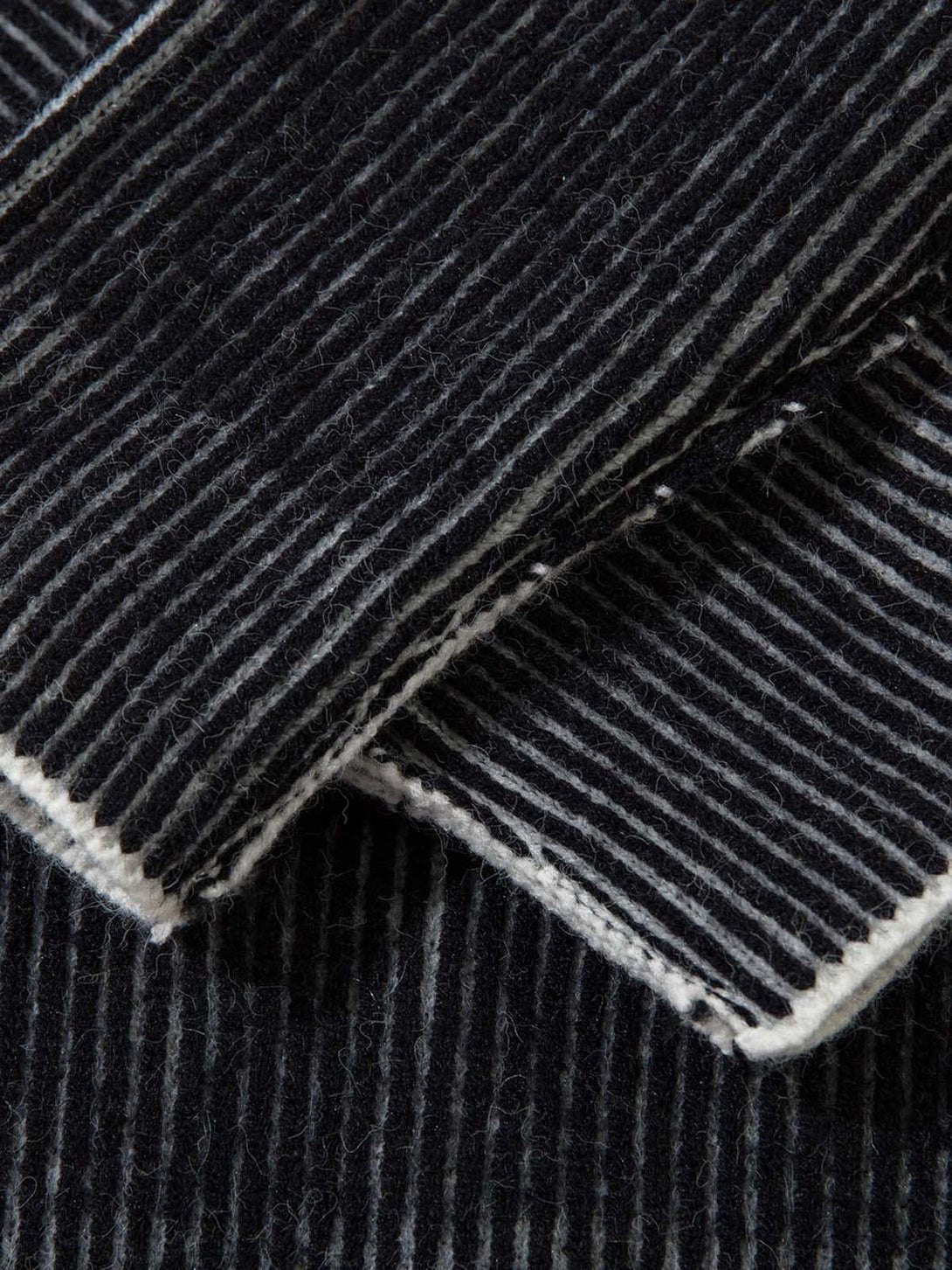 Intricate look at TALISHKO's sweater fabric, highlighting its textured ribbed stripes.