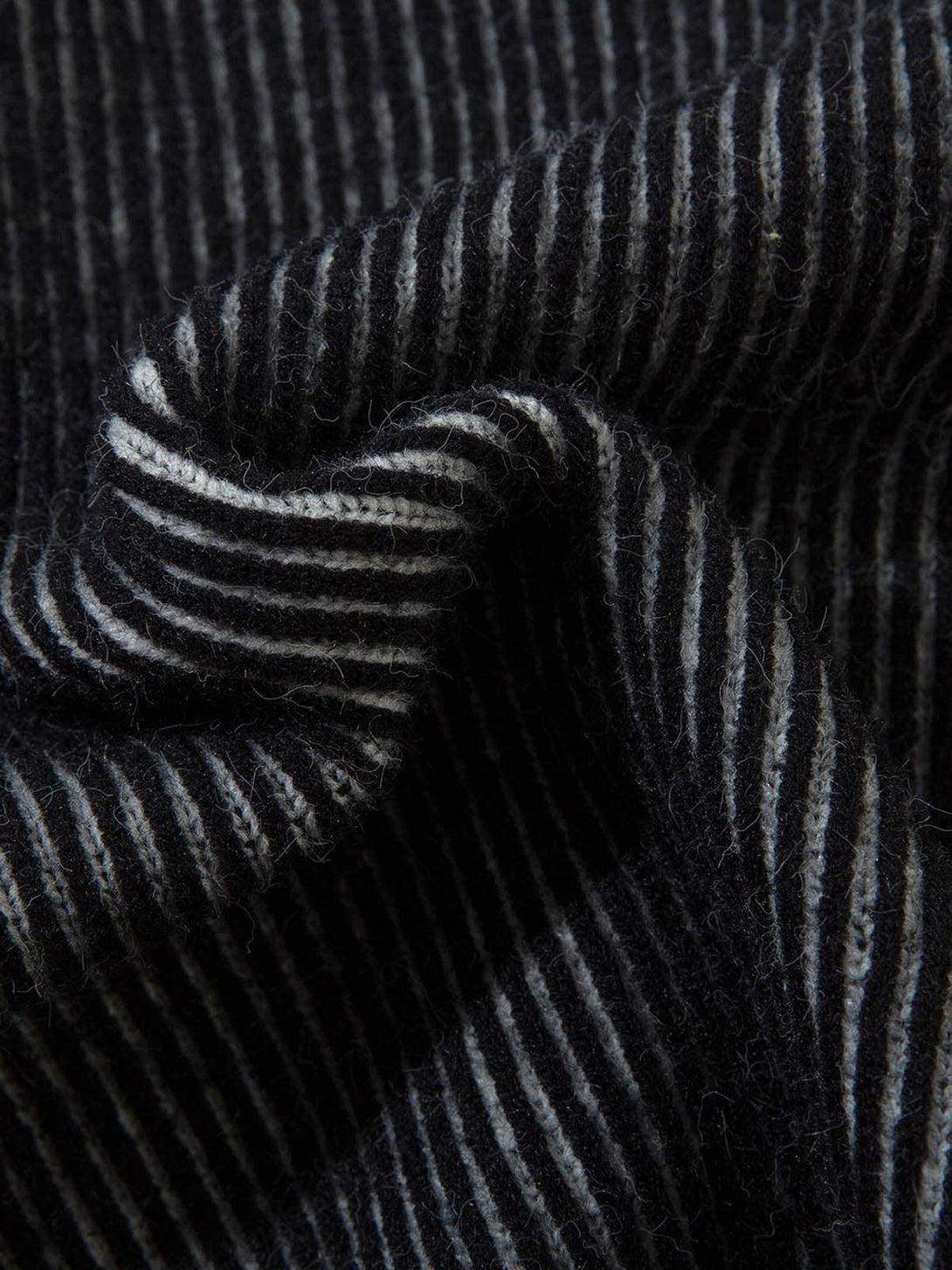 Texture and pattern showcased in TALISHKO's sweater, highlighting intricate ribbed stripes.