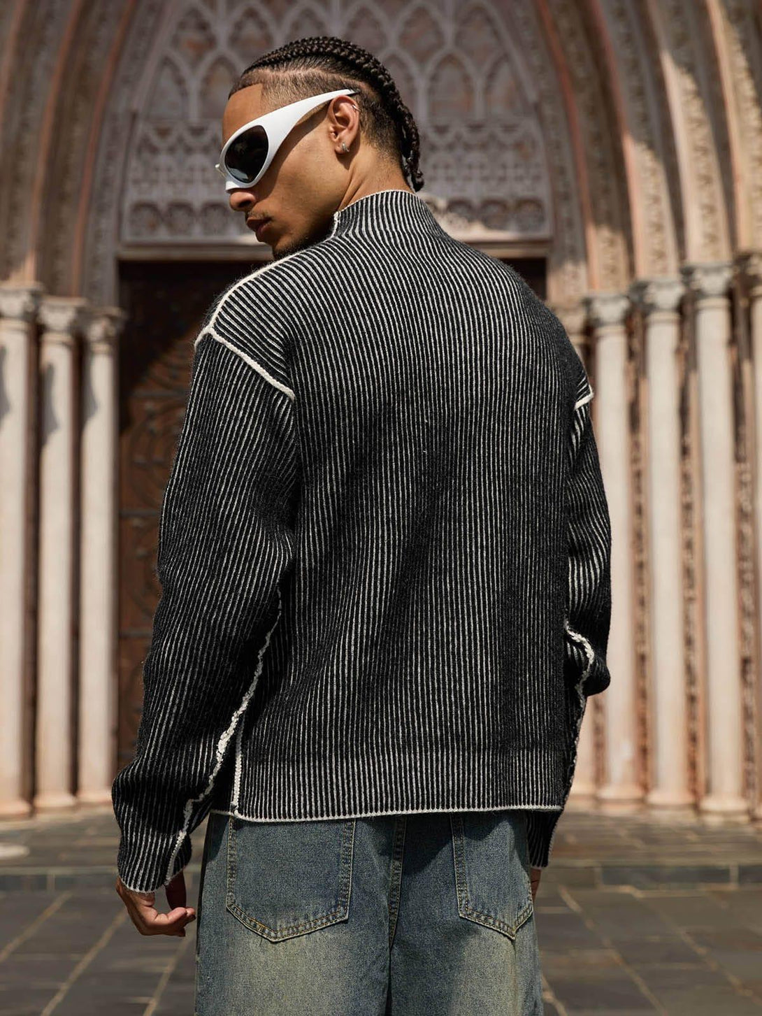 Model in a TALISHKO sweater, showcasing its textured design with striking white sunglasses.