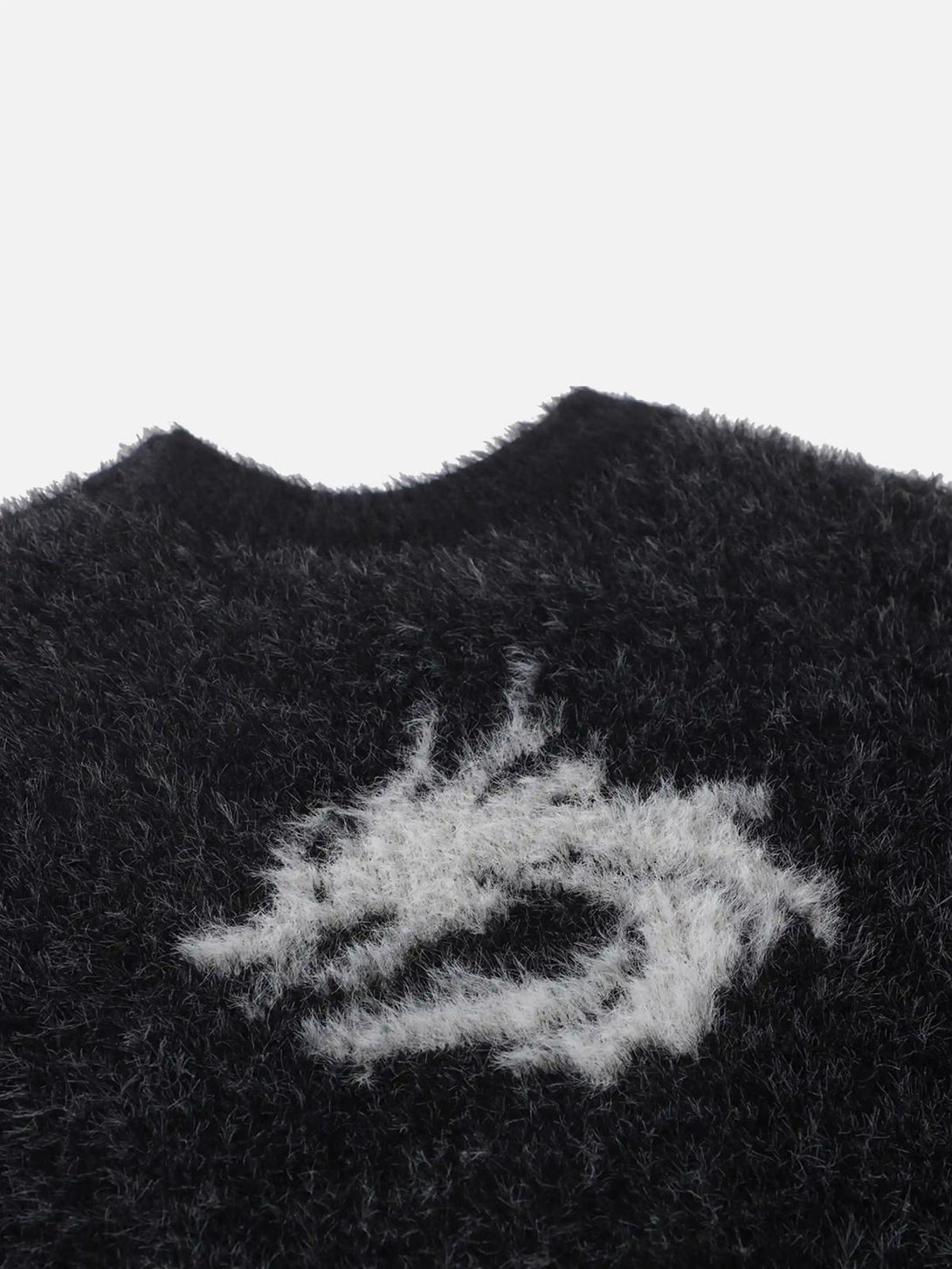 Focusing on the fuzzy texture and dragon design detail of the mohair sweater by TALISHKO.