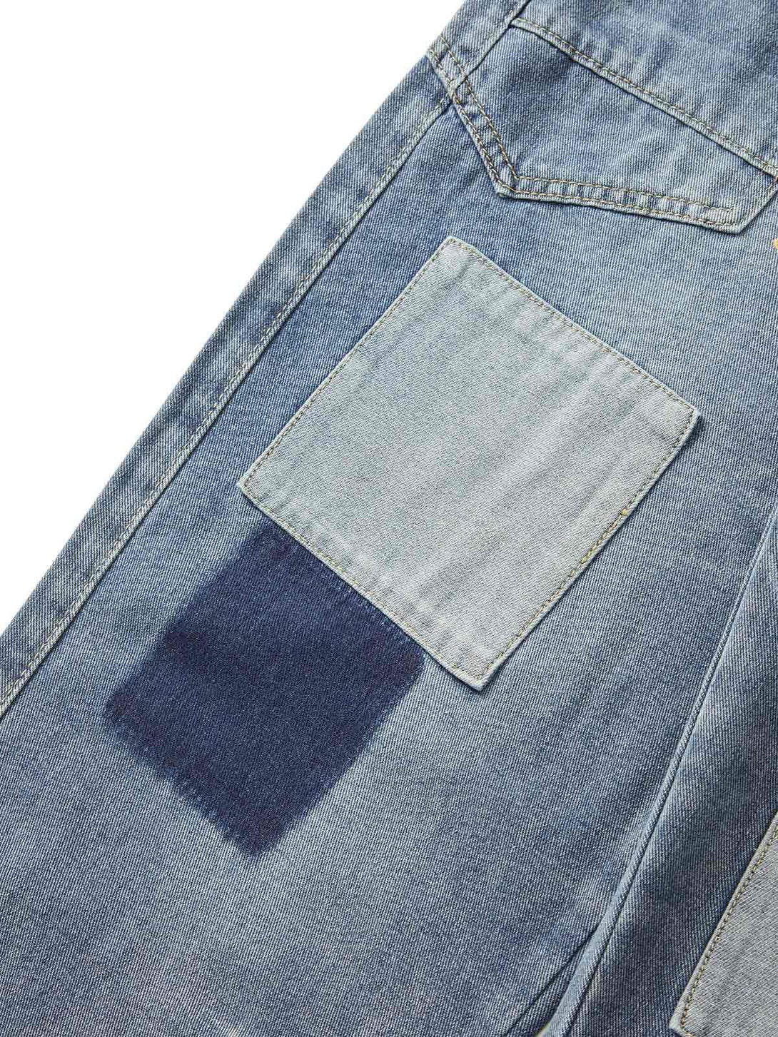 Denim patchwork and stitching detail on TALISHKO jeans, highlighting unique washed texture.