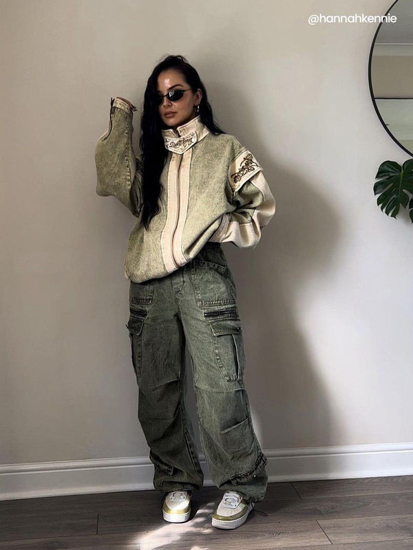 Model wearing oversized jacket and drawstring cargo jeans by TALISHKO, styled with sporty sneakers.