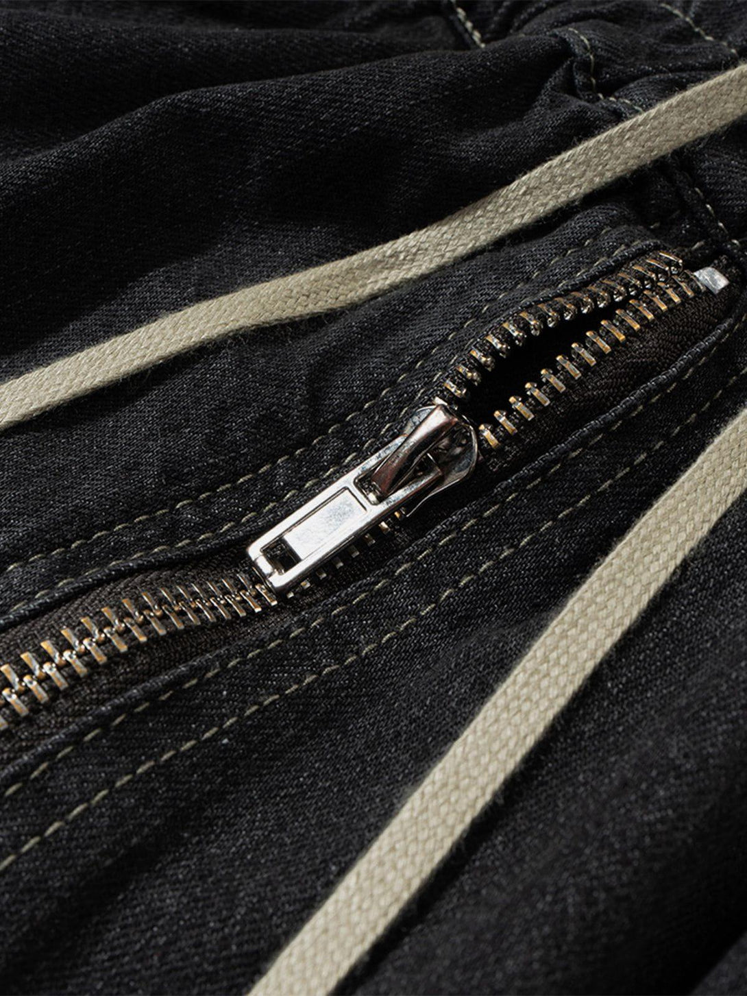 A detailed view of TALISHKO's drawstring washed jorts, focusing on the zipper and stitching.